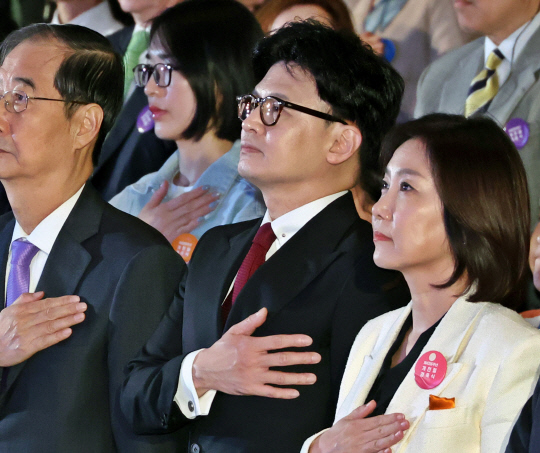 한동훈(가운데) 국민의힘 대표가 3일 오전 서울 종로구 세종문화회관 대극장에서 열린 제4356주년 개천절 경축식에서 국민의례를 하고 있다. 왼쪽은 한덕수 국무총리, 오른쪽은 허은아 개혁신당 대표.<연합뉴스 사진 갈무리>